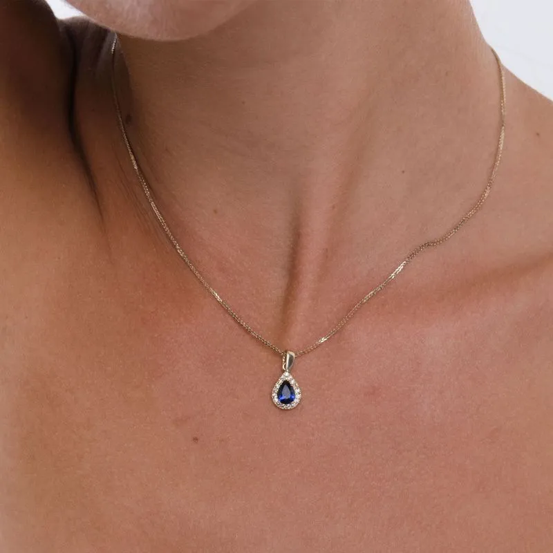 Yellow gold drop necklace with white zircons and a blue zircon in the center